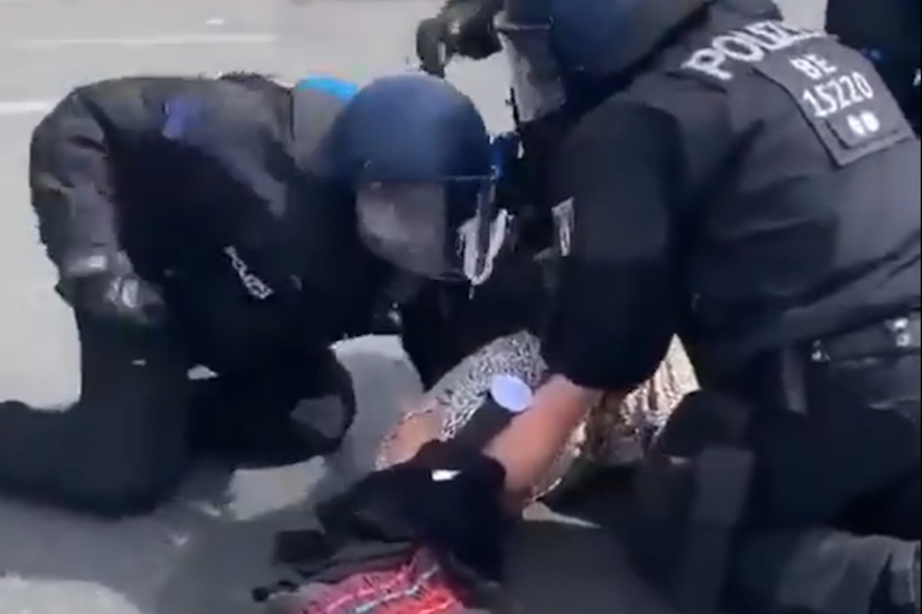 Ein Polizist schlägt auf der Straße des 17. Juni eine Frau.