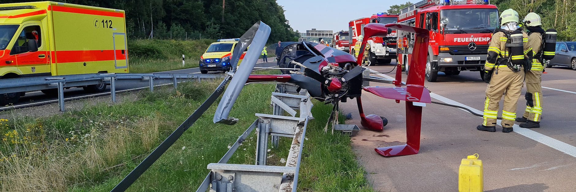 Einsatzkräfte der Feuerwehr stehen an der Absturzstelle.