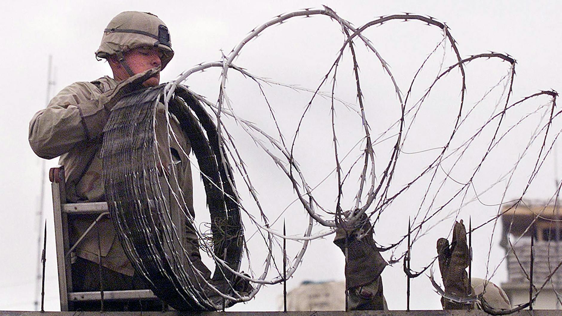 Ein US-Soldat sichert die amerikanische Botschaft in Kabul mit Stacheldraht (Archivbild).