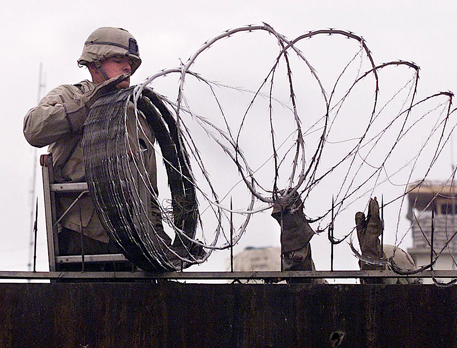 Ein US-Soldat sichert die amerikanische Botschaft in Kabul mit Stacheldraht (Archivbild).