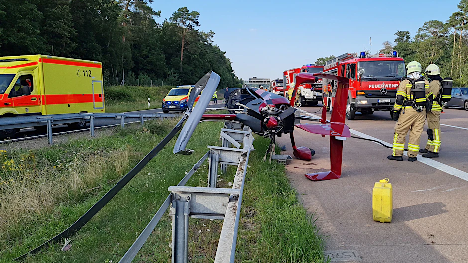 Michendorf: Einsatzkräfte der Feuerwehr stehen an der Absturzstelle des Tragschraubers am Autobahndreieck Nuthetal.