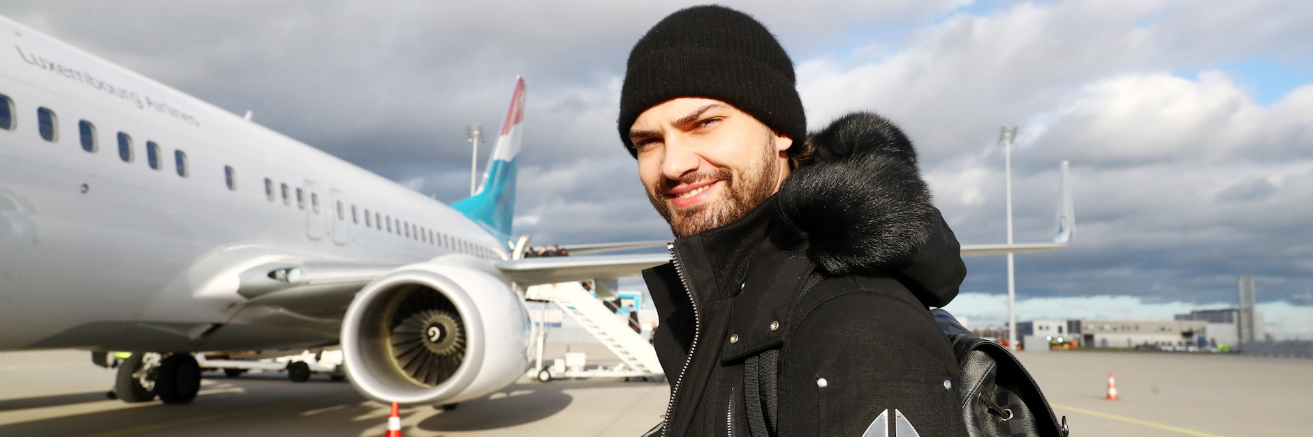 Jimi Blue Ochsenknecht vor einem Flugzeug.