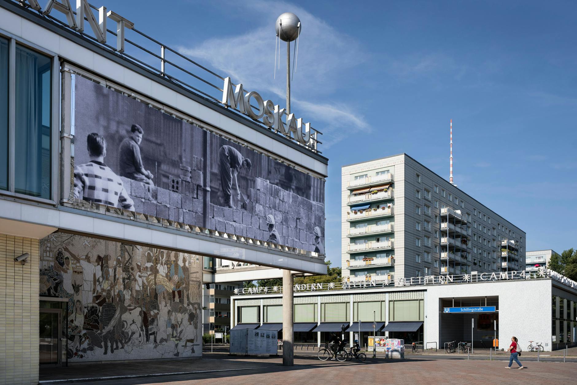 An image of the outside of Café Moskau show the Wall being built.