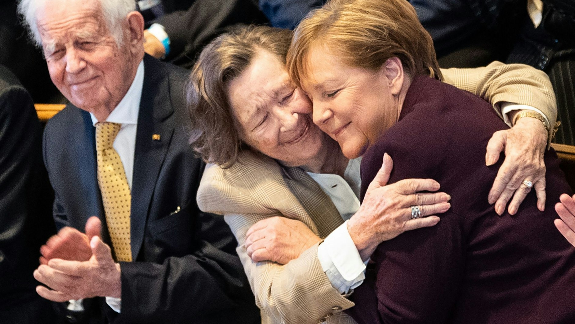 Kanzlerin Angela Merkel (CDU, r.) wird von Kurt Biedenkopfs Ehefrau Ingrid umarmt.