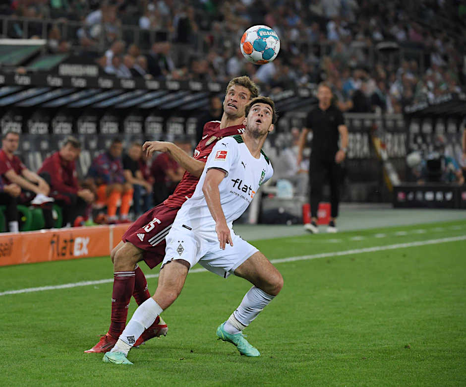 Joe Scally (Mönchengladbach) und Thomas Müller (Bayern) kämpfen um den Ball.