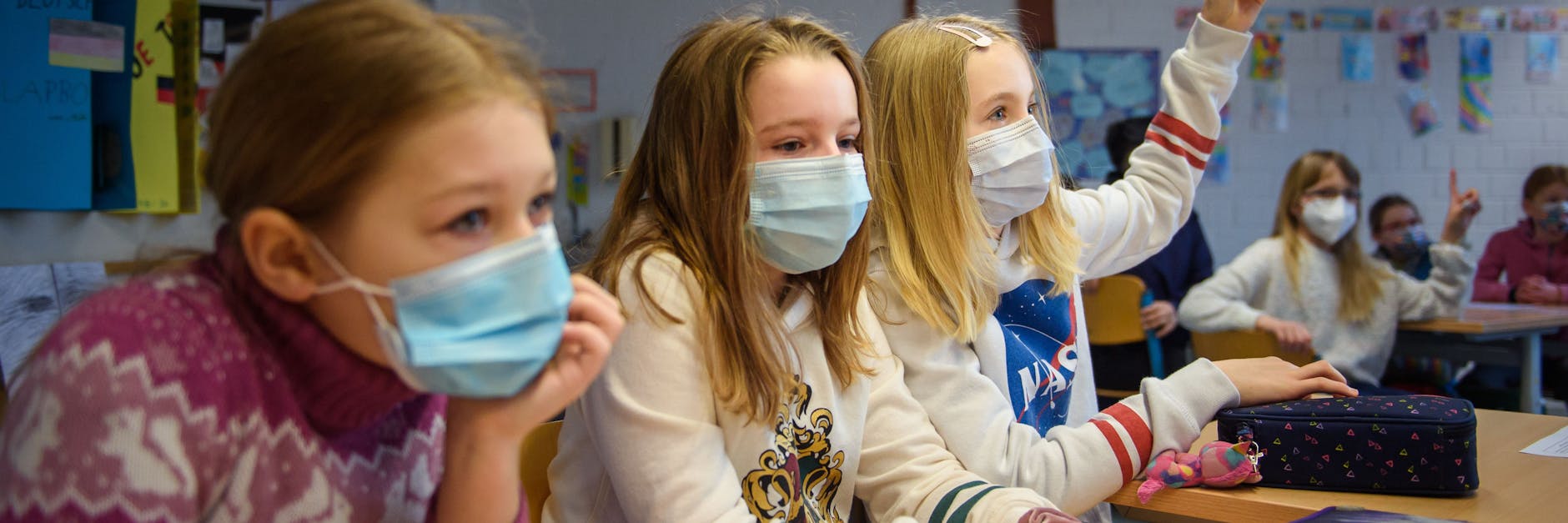 Eine Schülerin einer 4. Klasse hebt im Unterricht in einer Grundschule die Hand.