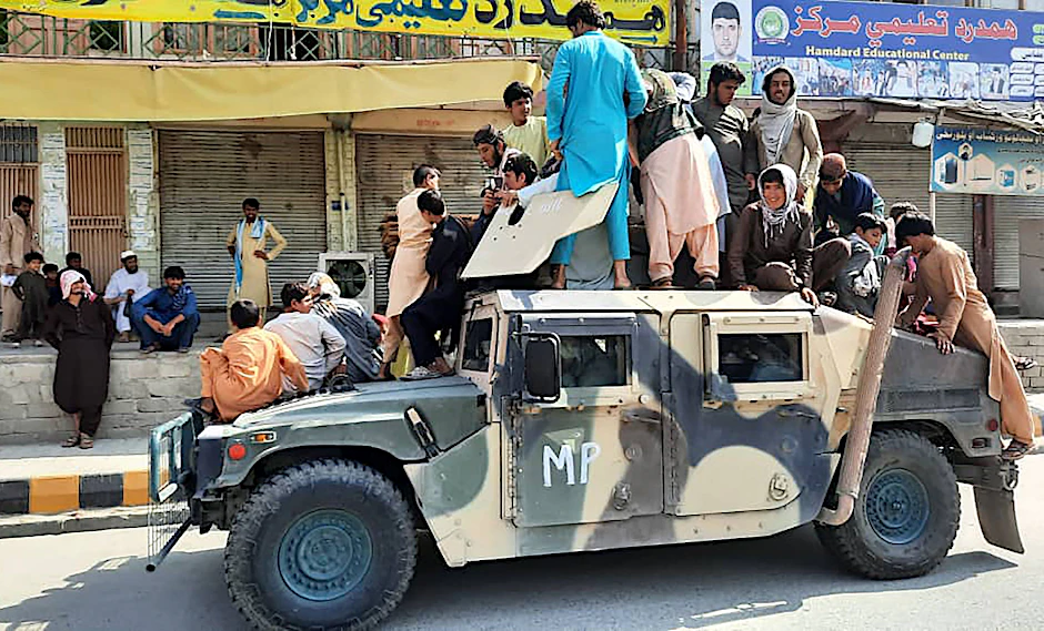 Taliban-Kämpfer und Anwohner sitzen auf einem erbeuteten Humvee der afghanische&nbsp;Armee.