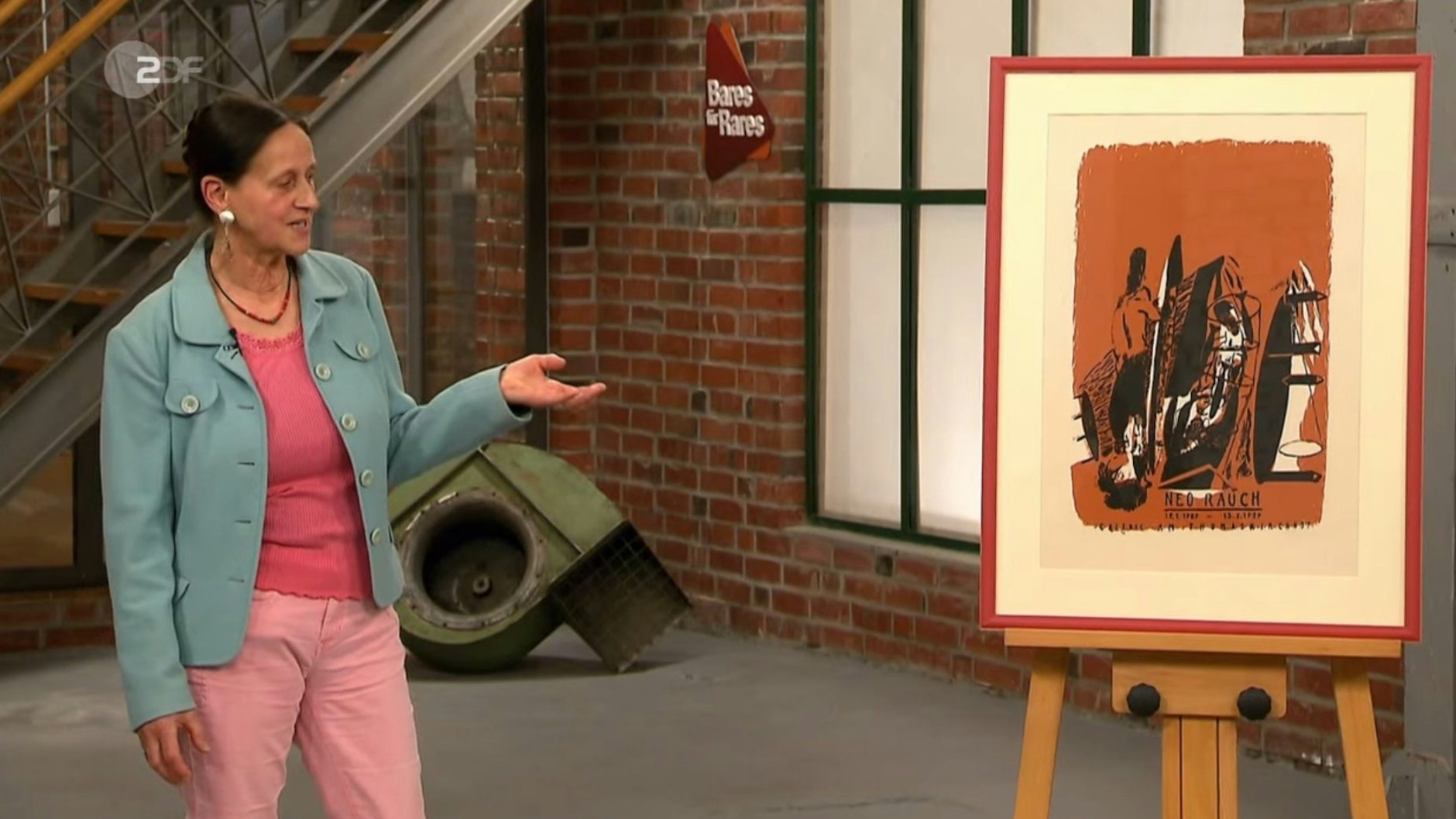 Im „Bares für Rares“-Verkaufsraum hat die Kandidatin viel über ihr Plakat zu erzählen.