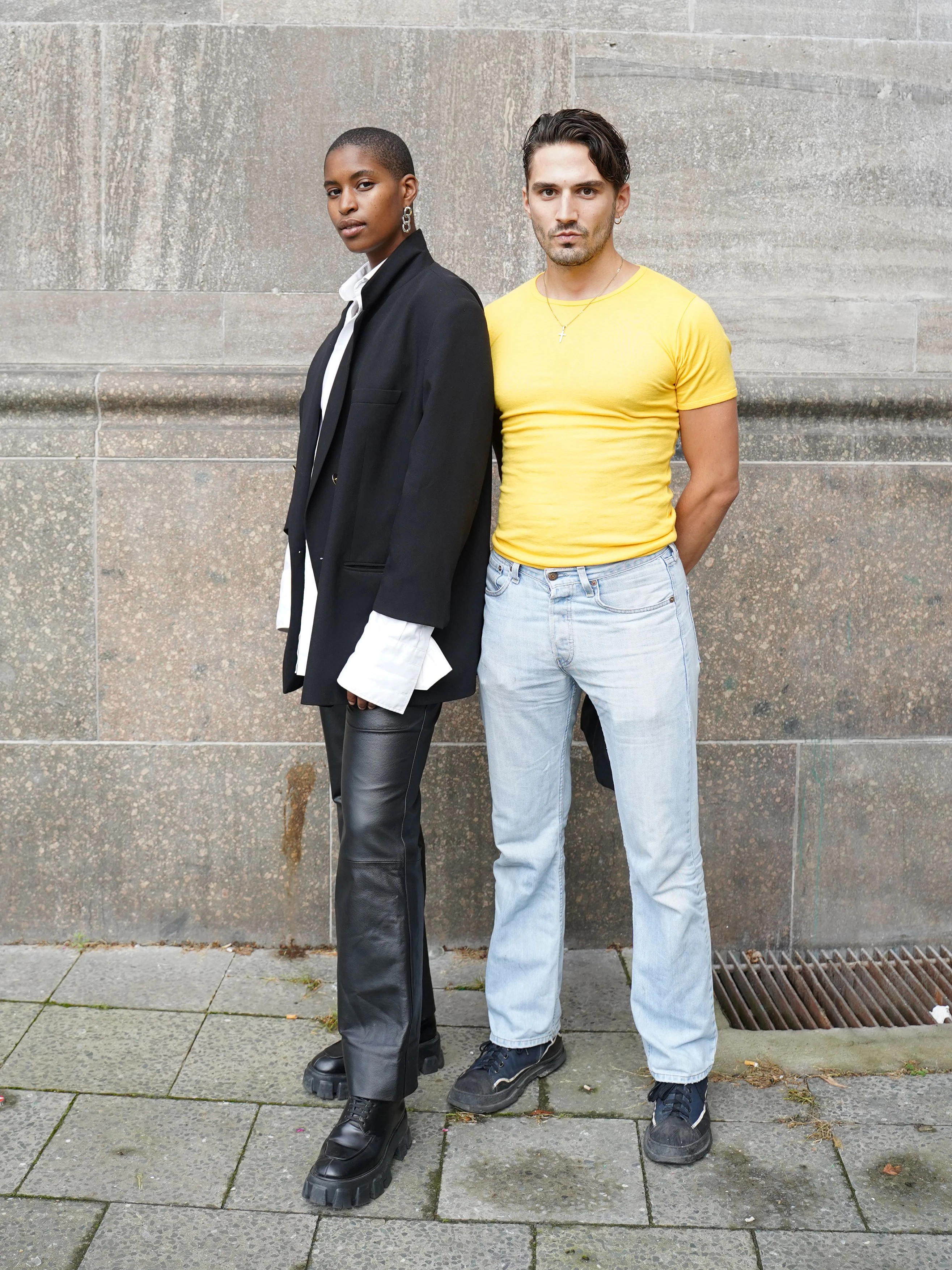 Diese zwei stylischen Wahlberliner sind „best friends“, wie sie sagen – und unterwegs in Richtung Boxhagener Platz. Die Webentwicklerin Déborah trägt ein schwarz-weißes Vintage-Outfit aus Blazer, Bluse und Lederhose. Auch der Sozialarbeiter William trägt einen Secondhand-Look aus sonnengelbem T-Shirt und hellblauer Jeans.
