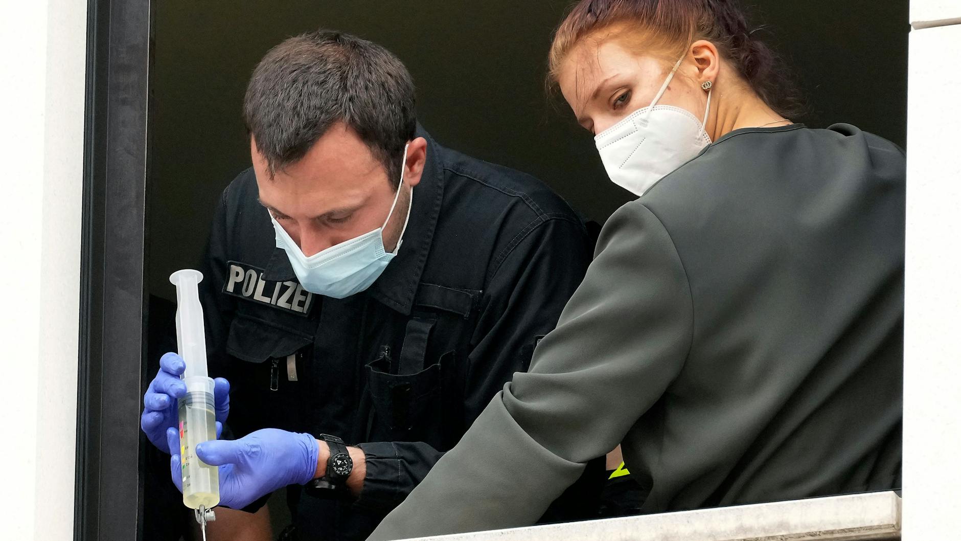 Ein weiterer Polizist verwendet ein Lösungsmittel, um die Hand dieser Demonstrantin zu lösen. 