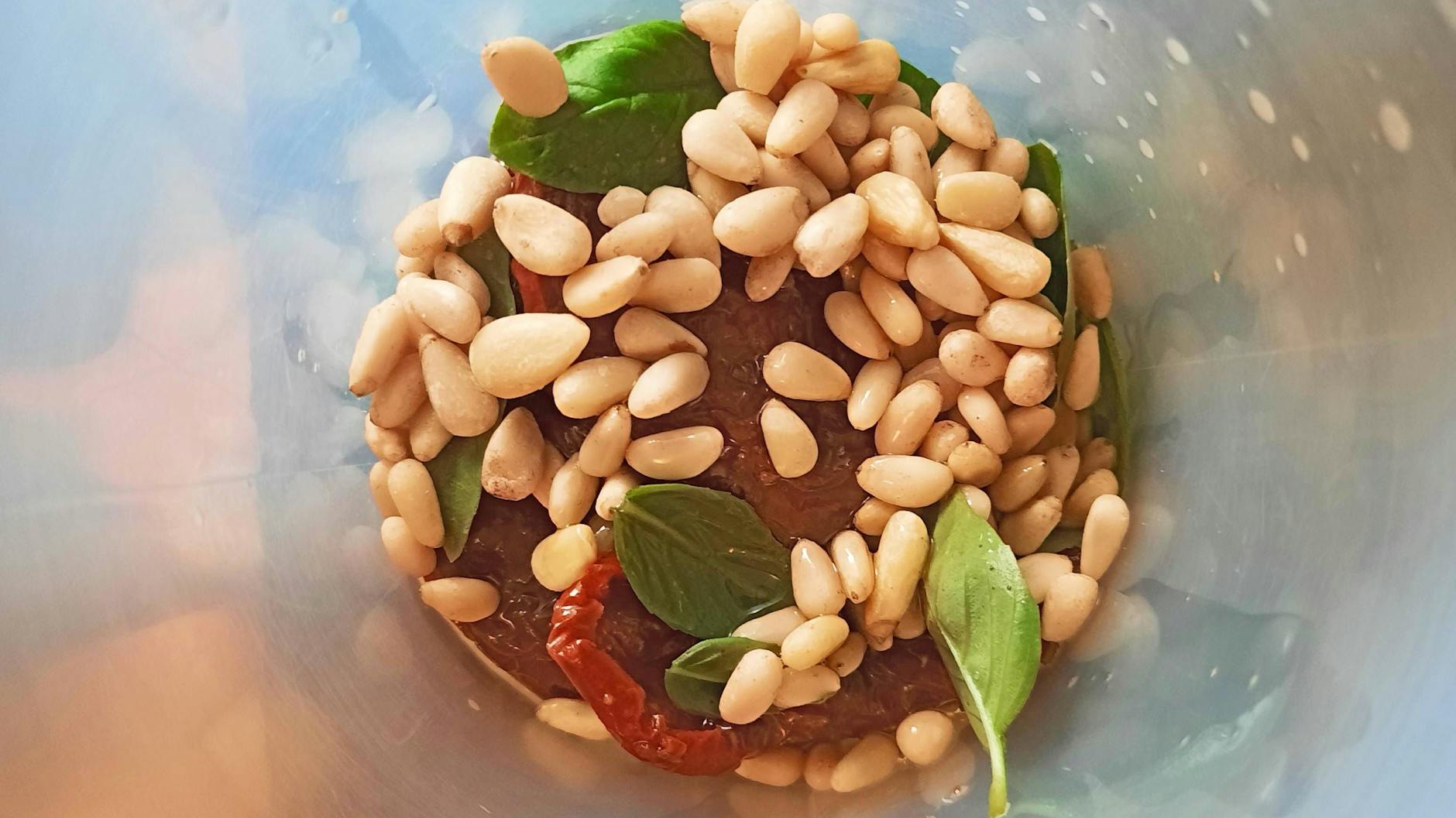 Pinienkerne, Knoblauch, Basilikum und getrocknete Tomaten werden mit Olivenöl, Zitronensaft, Kräutern und Gewürzen zu einem leckeren Pesto Rosso.