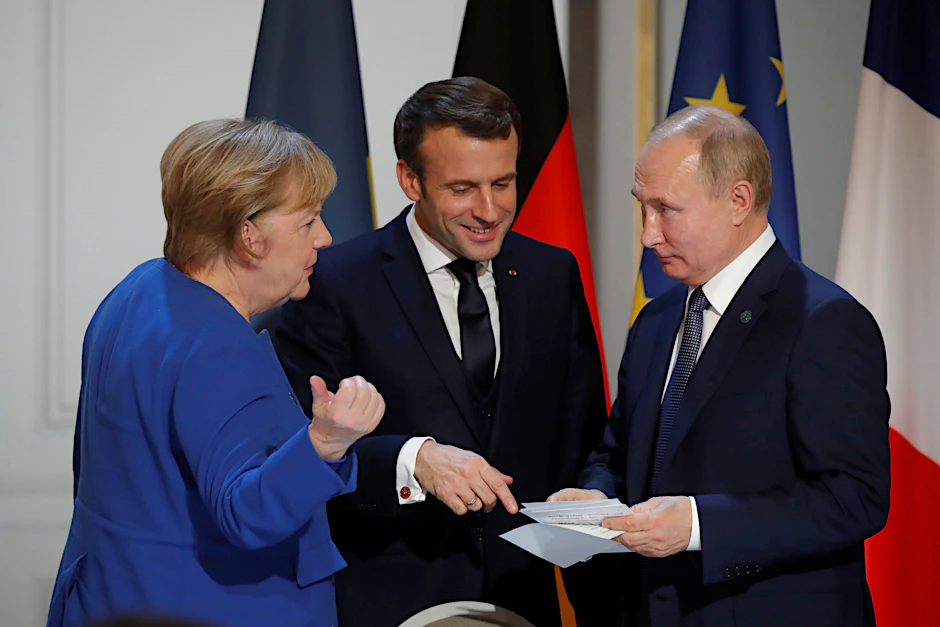 Bundeskanzlerin Angela Merkel, der französische Präsident Emmanuel Macron und der russische Präsident Wladimir Putin nehmen 2019 an einer gemeinsamen Pressekonferenz im Pariser Élysée-Palast teil.