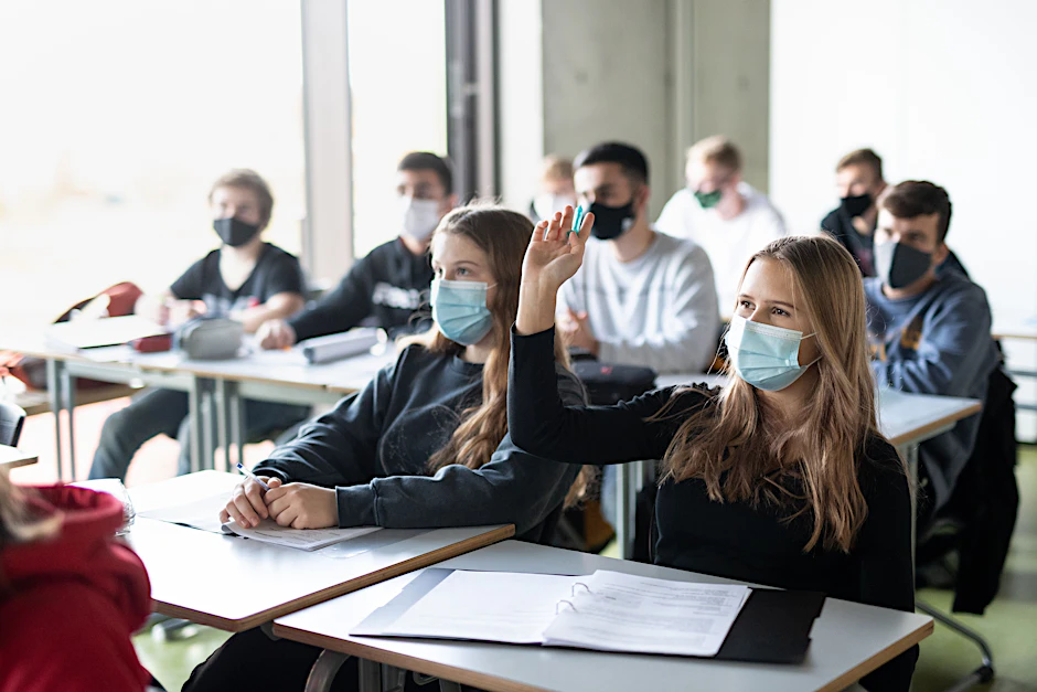 Maskierte Schülerinnen und Schüler im Präsenzunterricht.