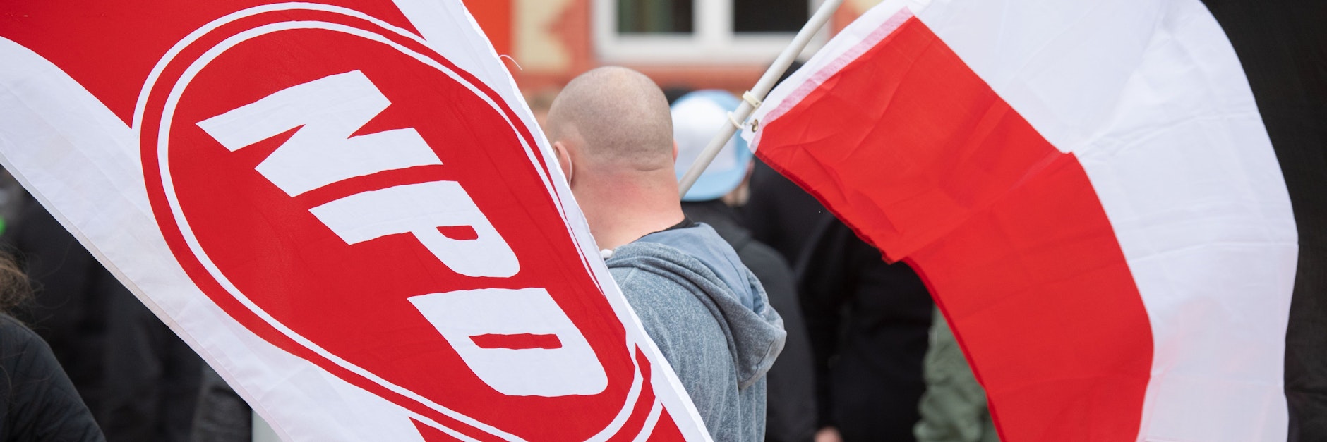 Mit wehenden Fahnen ziehen Anhänger der rechtsextremen NPD durch die Innenstadt von Greifswald.