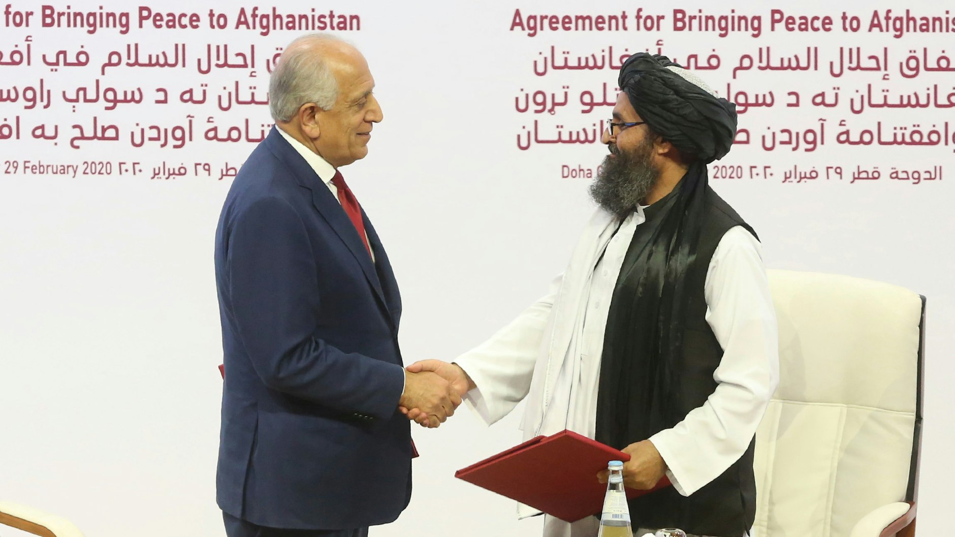 Zalmay Khalilzad, US-Sondergesandte für Aussöhnung in Afghanistan, und Mullah Abdul Ghani Baradar, Leiter des politischen Büros der Taliban, schütteln sich am 29. Februar 2020 in Doha die Hand, nachdem sie ein Abkommen über Wege zu einem Frieden zwischen den USA und der militant-islamistischen Taliban unterzeichnet haben.