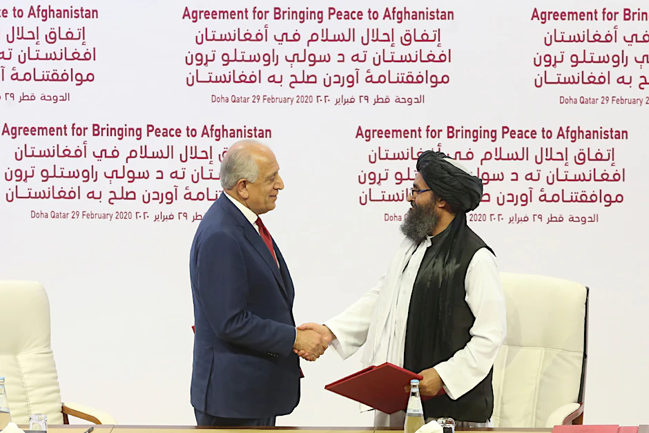 Zalmay Khalilzad, US-Sondergesandte für Aussöhnung in Afghanistan, und Mullah Abdul Ghani Baradar, Leiter des politischen Büros der Taliban, schütteln sich am 29. Februar 2020 in Doha die Hand, nachdem sie ein Abkommen über Wege zu einem Frieden zwischen den USA und der militant-islamistischen Taliban unterzeichnet haben. 