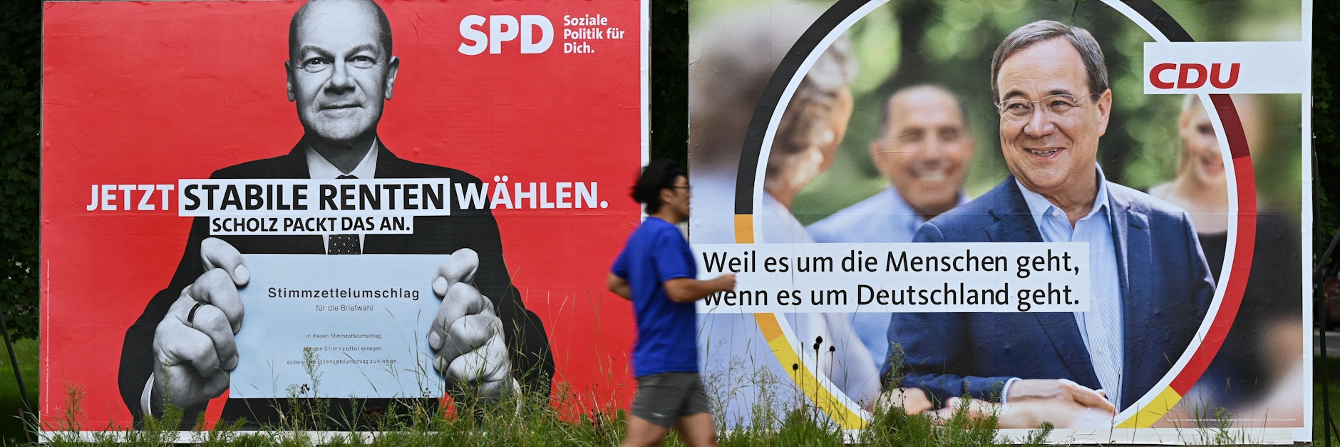 Ein Mann joggt an Wahlplakaten der SPD mit Olaf Scholz (l.) und der CDU mit Armin Laschet vorbei.&nbsp;