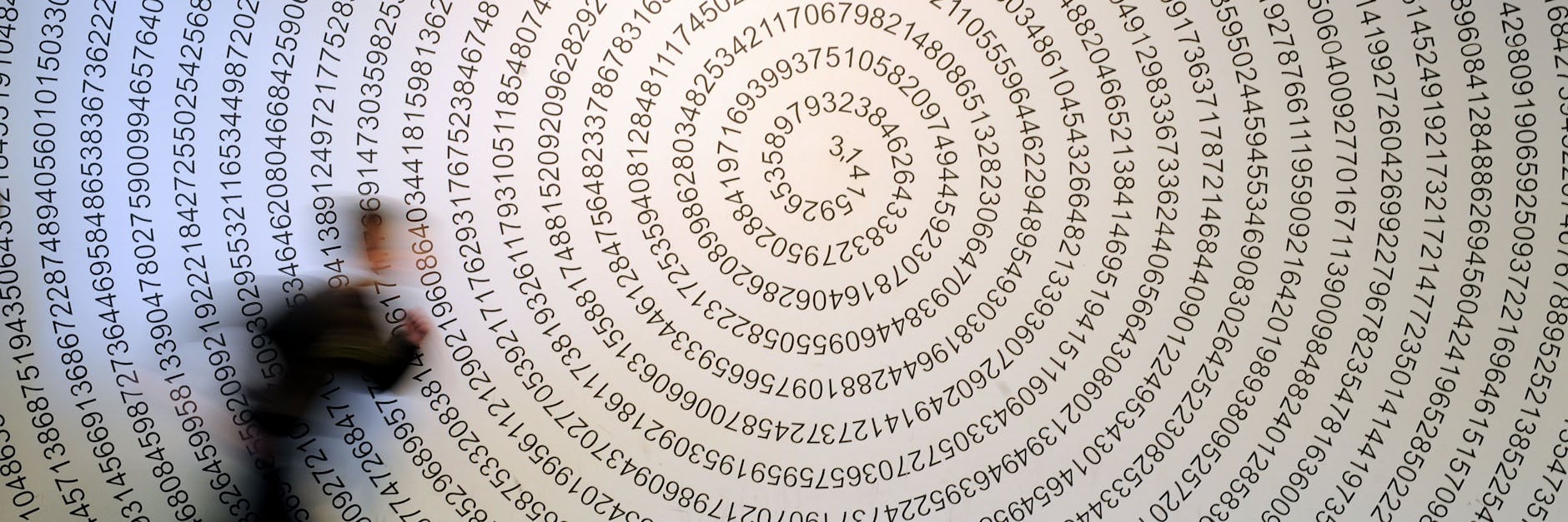 Ein Schulkind läuft im Mitmachmuseum «Mathematikum» an der auf eine Wand geschriebenen Kreiszahl Pi vorbei.