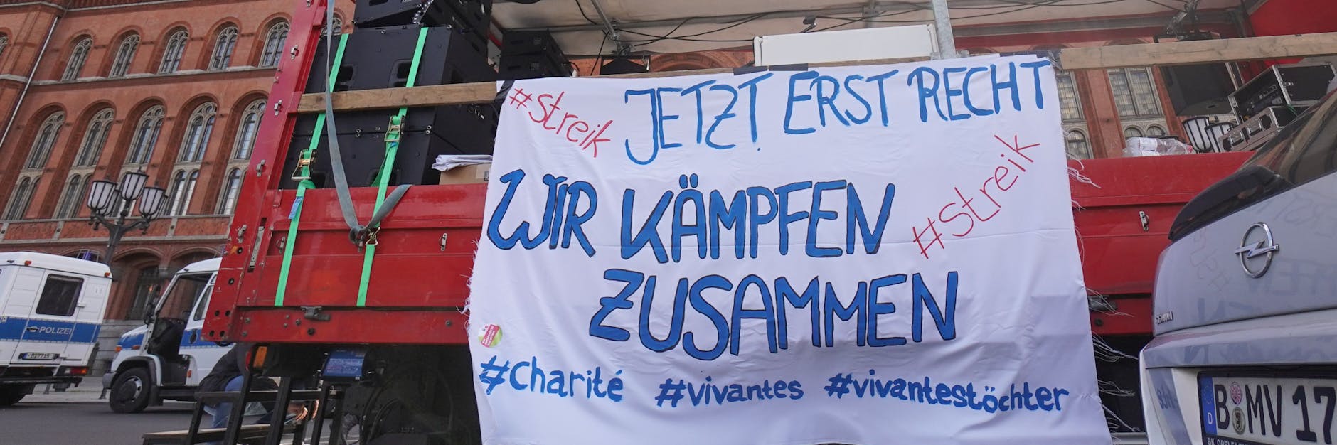 Ein Transparent mit der Aufschrift „Jetzt erst recht - wir kämpfen zusammen“ ist vor dem Roten Rathaus zu sehen.