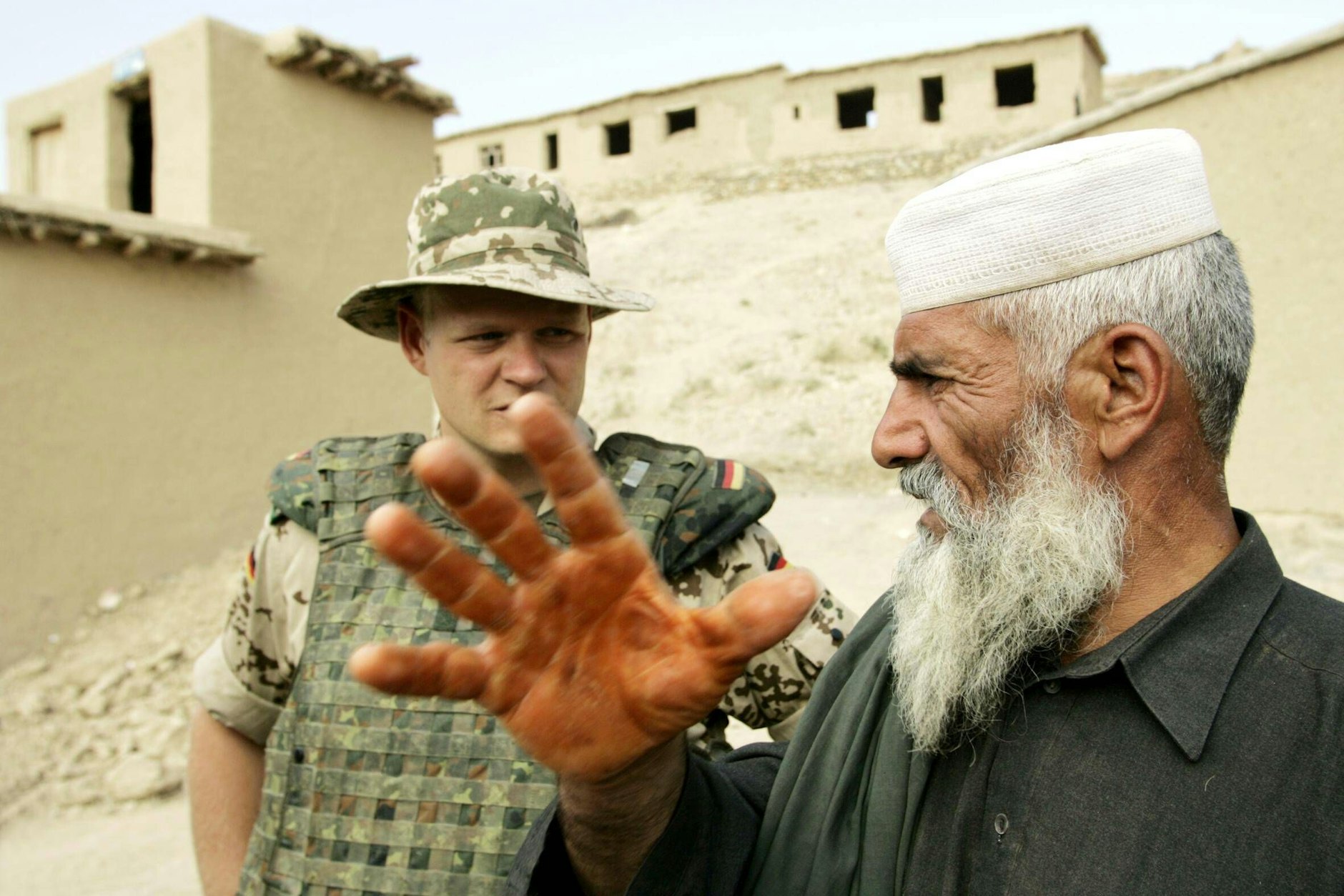 Ein deutscher ISAF-Soldat spricht mit einem Ortskundigen. 