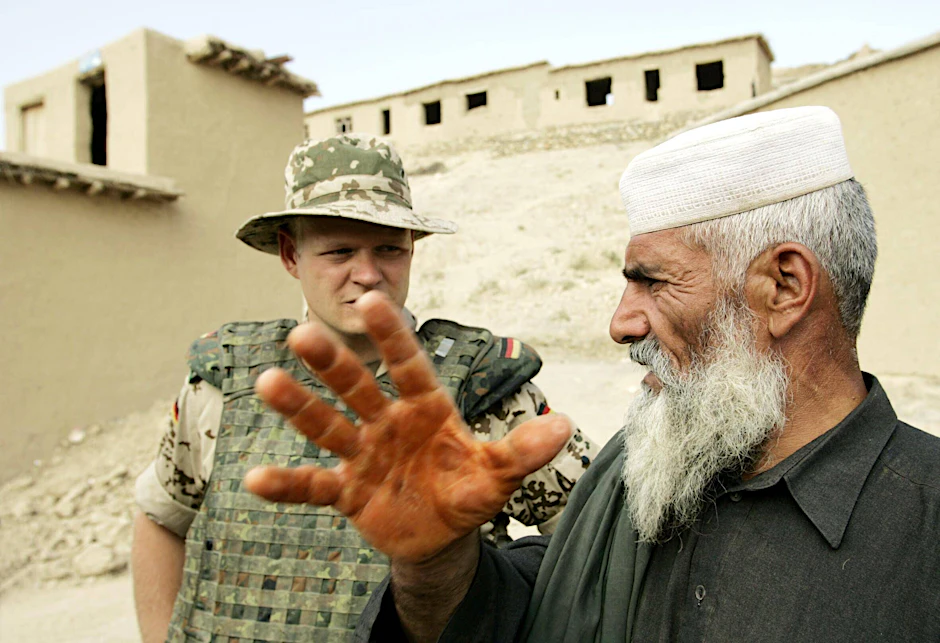Ein deutscher ISAF-Soldat spricht mit einem Ortskundigen.&nbsp;