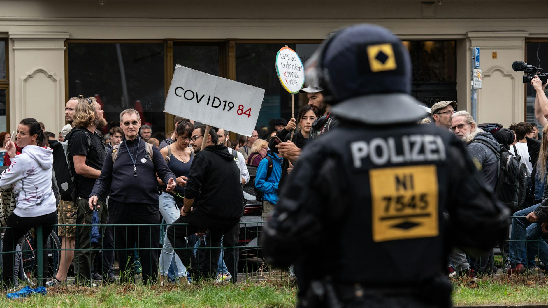 Ein Polizeibeamter steht auf der Danziger Straße vor einer Gruppe von Demonstranten gegen die Corona-Politik. Auch am Sonntag fanden in Berlin, teils trotz Verboten, Demonstrationen gegen die deutsche Corona-Politik statt.