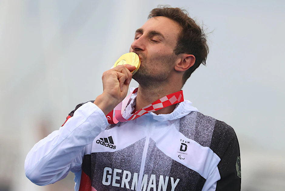 Die erste deutsche Rakete hat gezündet: Triathlet Martin Schulz küsst bei der Siegerehrung die Goldmedaille.