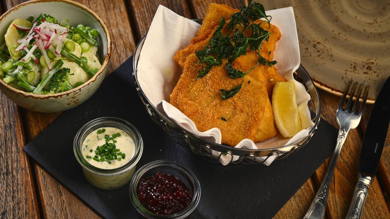 Das „Jolesch“ in Berlin serviert Petersilienkartoffeln, also Salzkartoffel in Butter und gehackter Petersilie geschwenkt, dazu Blattsalat oder „Häuptelsalat“ (Kopfsalat).<br>