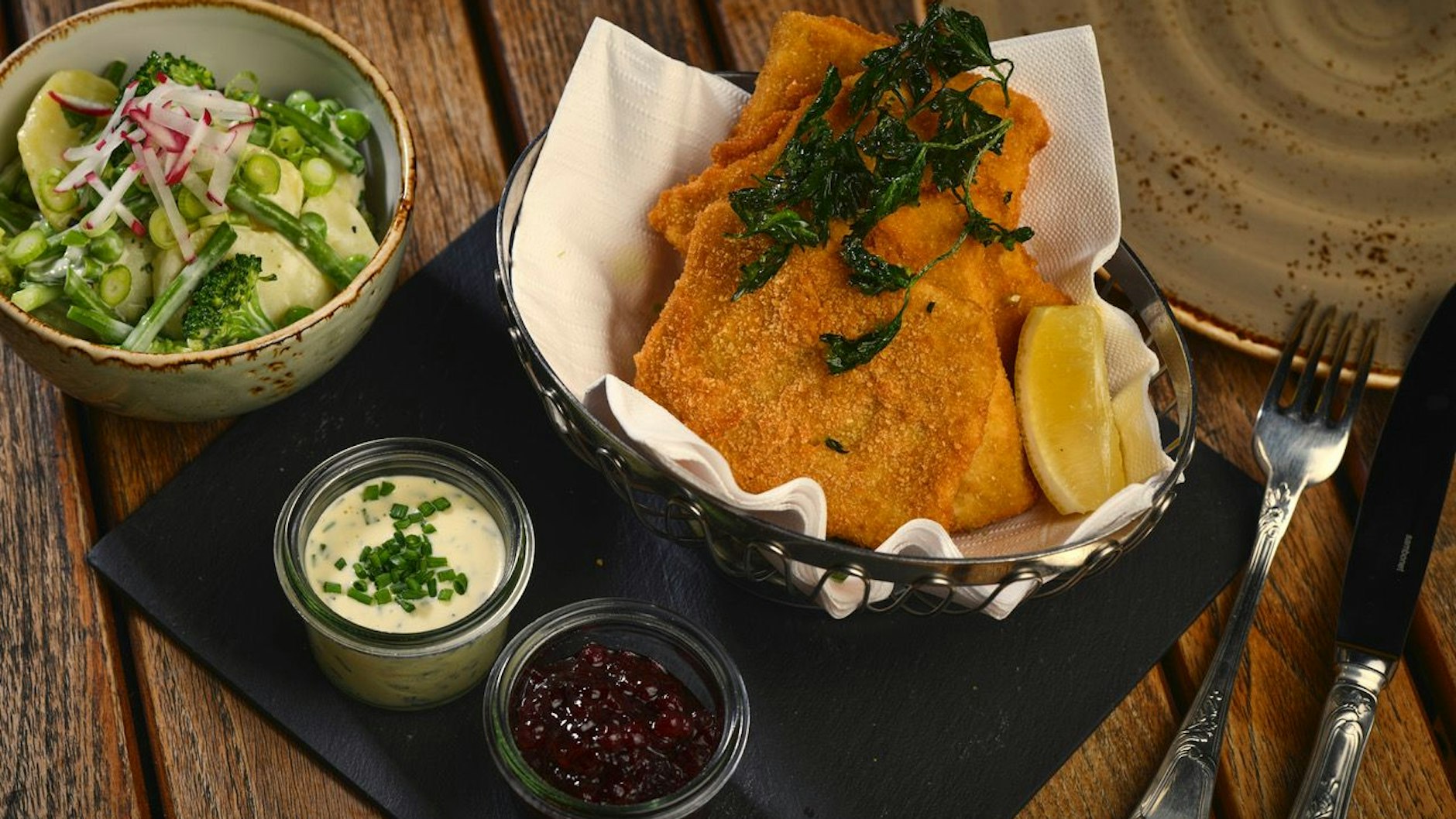 Das „Jolesch“ in Berlin serviert Petersilienkartoffeln, also Salzkartoffel in Butter und gehackter Petersilie geschwenkt, dazu Blattsalat oder „Häuptelsalat“ (Kopfsalat).<br>