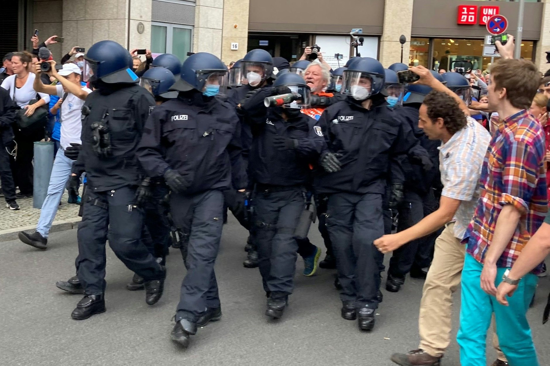 Polizisten nehmen einen angeblichen Rädelsführer der Proteste fest.