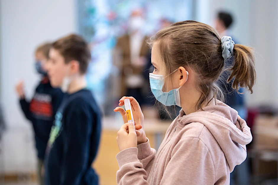 Eine Viertklässlerin hält einen Corona-Test in ihren Händen.&nbsp;Die Gesundheitsämter wollen künftig nur noch Kinder mit einem positiven PCR-Test in eine 14-tägige Quarantäne schicken.