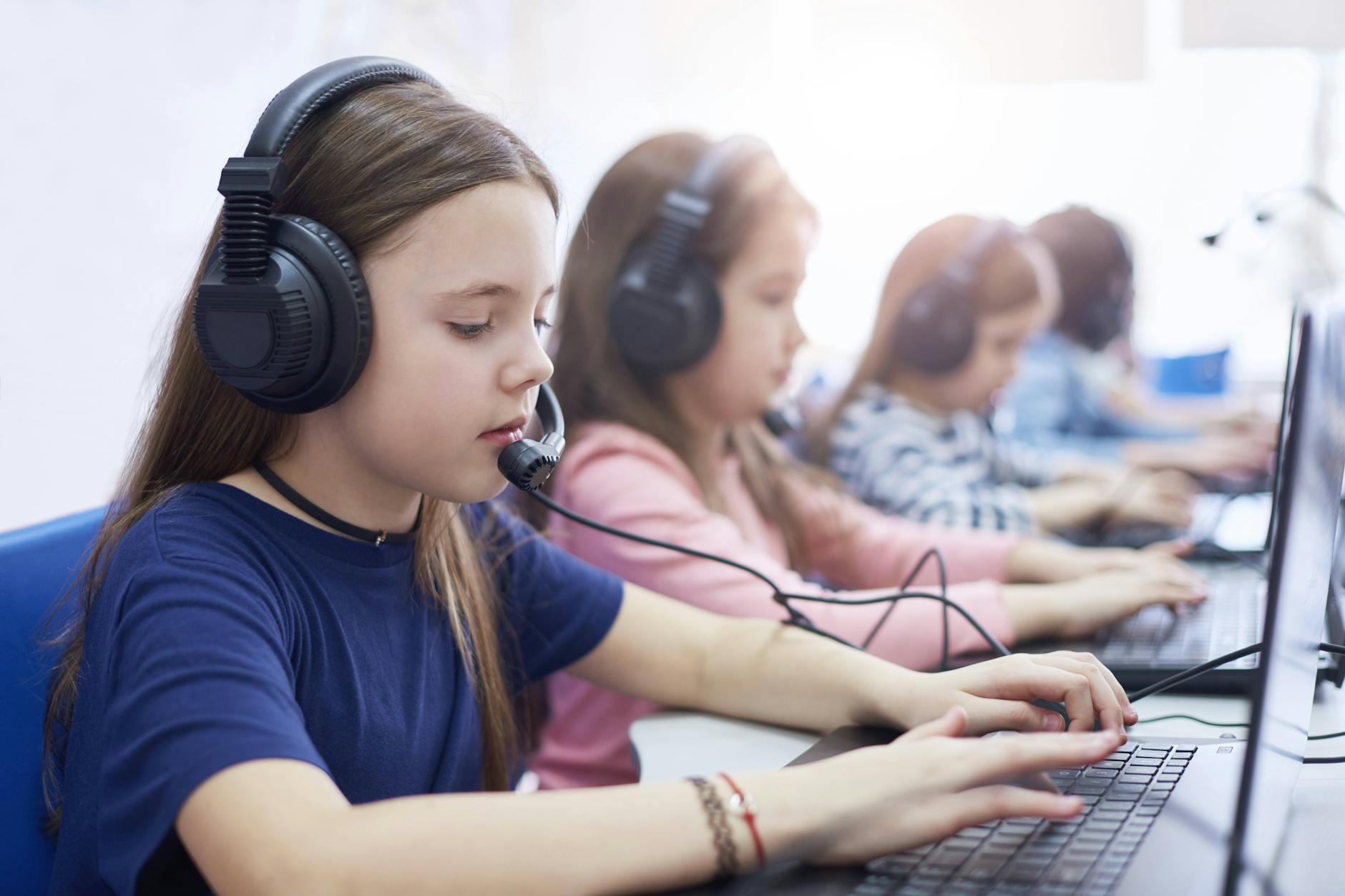 Mit Headset am PC: Mädchen in einer Schulklasse (Symbolbild)