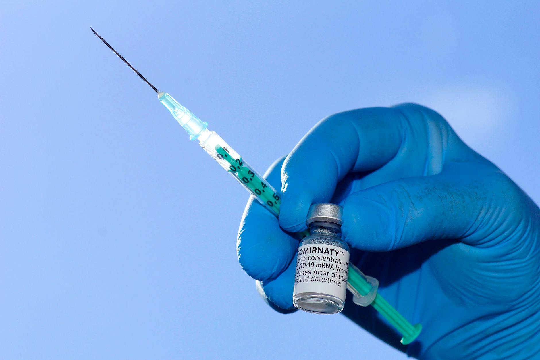 Dritte Corona-Impfung, ja oder nein? Ein Arzt hält eine Spritze und eine Ampulle mit Impfstoff von Biontech/Pfizer (Symbolbild).