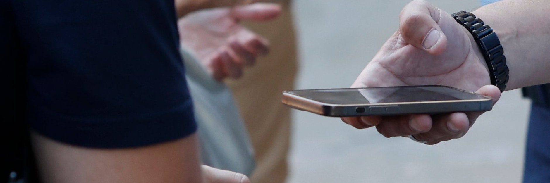 Ein Security-Mann kontrolliert das Handy eines Touristen.