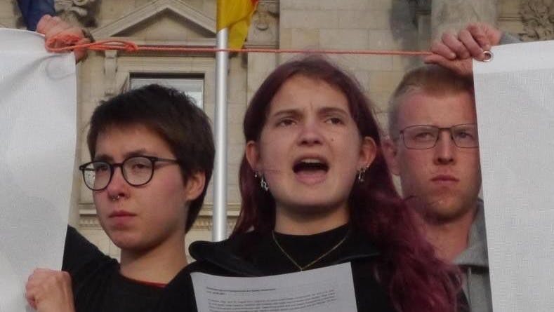 Die Hungerstreikenden verlesen ihre Erklärung vor dem Bundestag. In der Mitte steht die Aktivistin Mephisto, 18 Jahre alt.