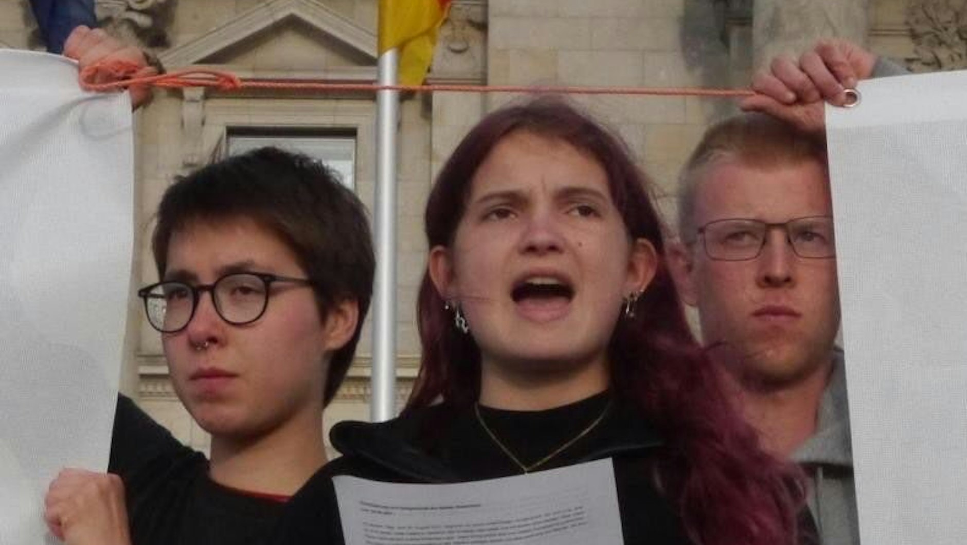 Die Hungerstreikenden verlesen ihre Erklärung vor dem Bundestag. In der Mitte steht die Aktivistin Mephisto, 18 Jahre alt.