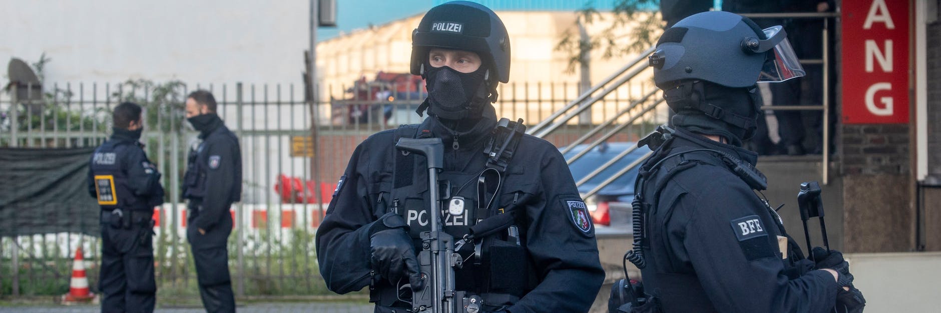 Polizisten stehen bei der Razzia vor einem abgesperrten Gebäude in Duisburg.