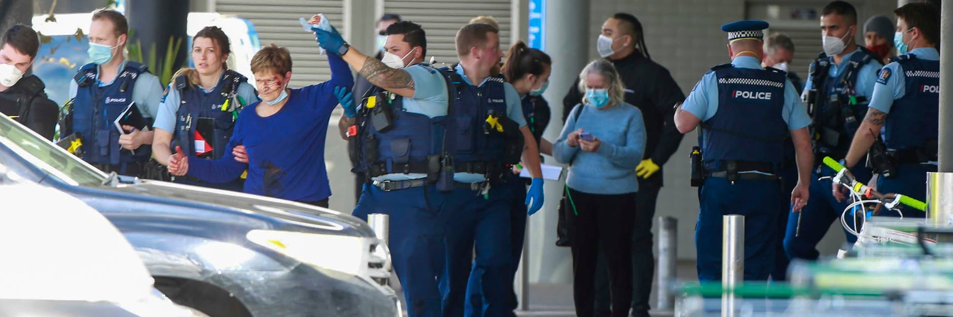 Polizisten und Sanitäter helfen verletzten Supermarkt-Kunden.
