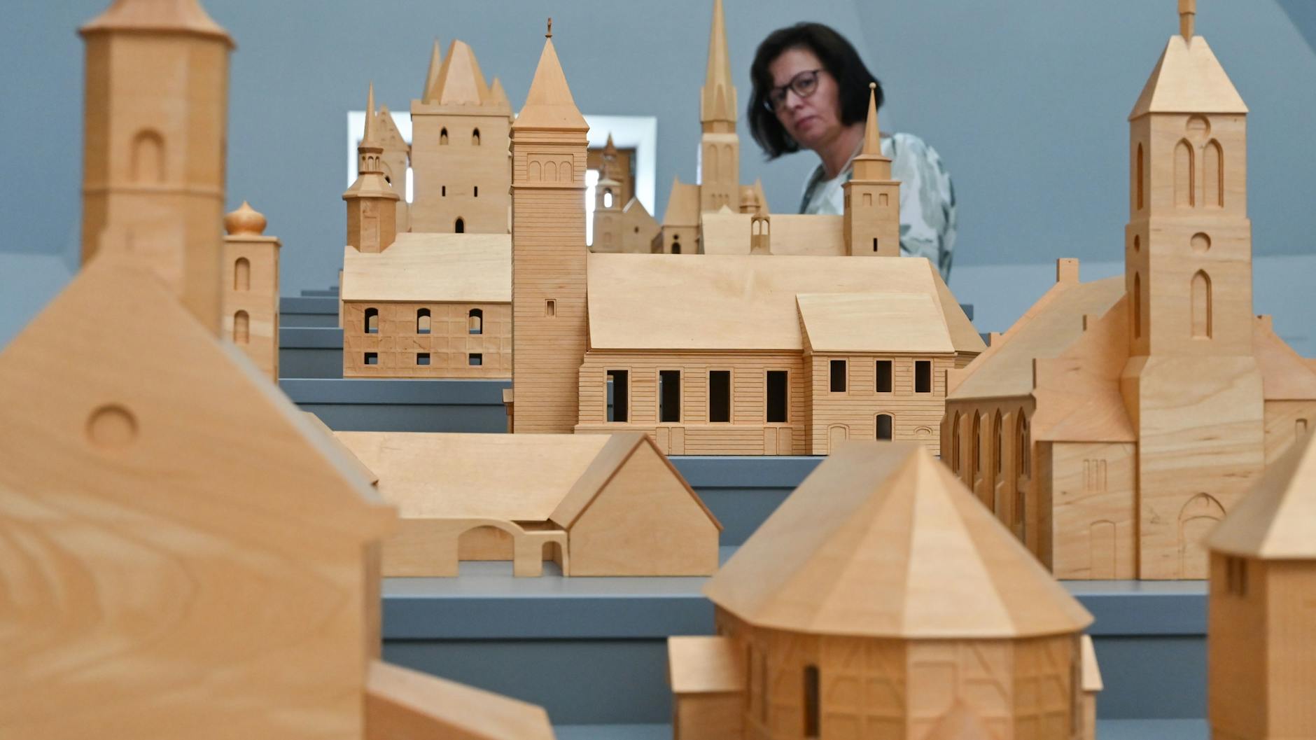 Dörthe Stein, Mitarbeiterin im „Archiv der verschwundenen Orte“ betrachtet hölzerne Modelle von Kirchen, die wegen der Förderung von Braunkohle abgerissen wurden.