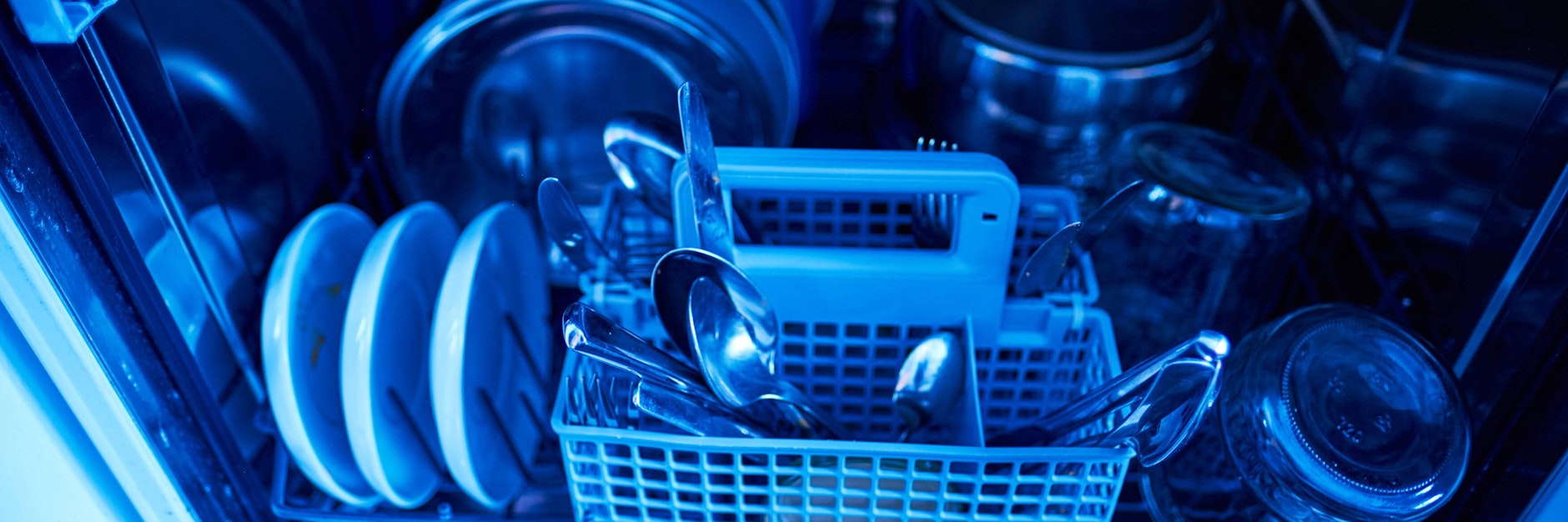 Auf den Tellern kleben noch Essenreste und das Besteck ist alles andere als sauber. Wenn Geschirr schmutzig aus der Spülmaschine kommt, ist eine Reinigung überfällig.