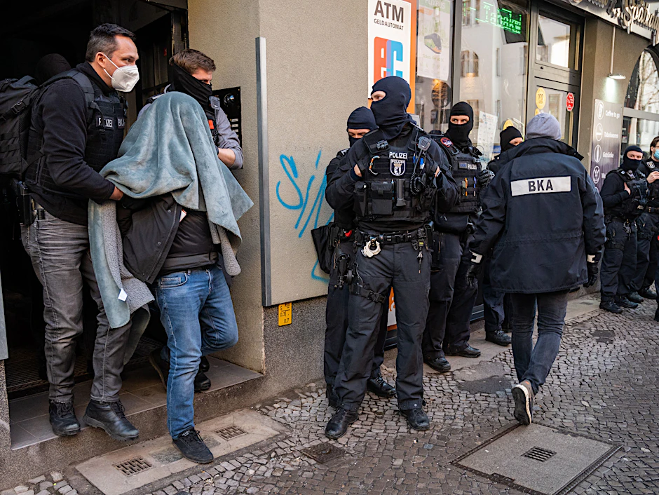 Ein Mann wird bei einer Razzia in Berlin mit einer Decke über dem Kopf von der Polizei abgeführt, nachdem Ermittler die Software Encrochat gehackt hatten.&nbsp;
