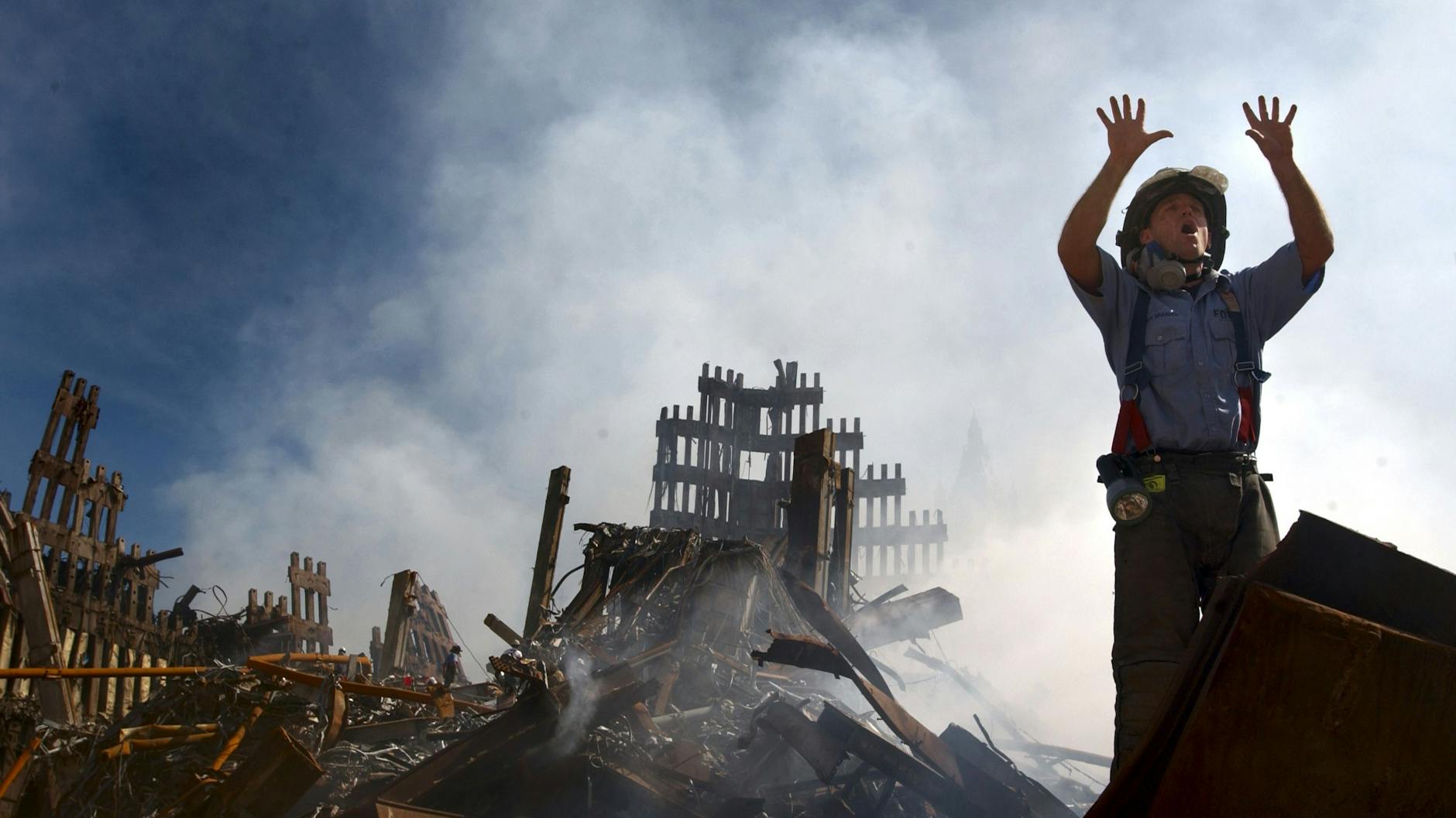 Ein New Yorker Feuerwehrmann fordert weitere Rettungskräfte auf, sich einen Weg in die Trümmer des World Trade Center in New York City zu bahnen.