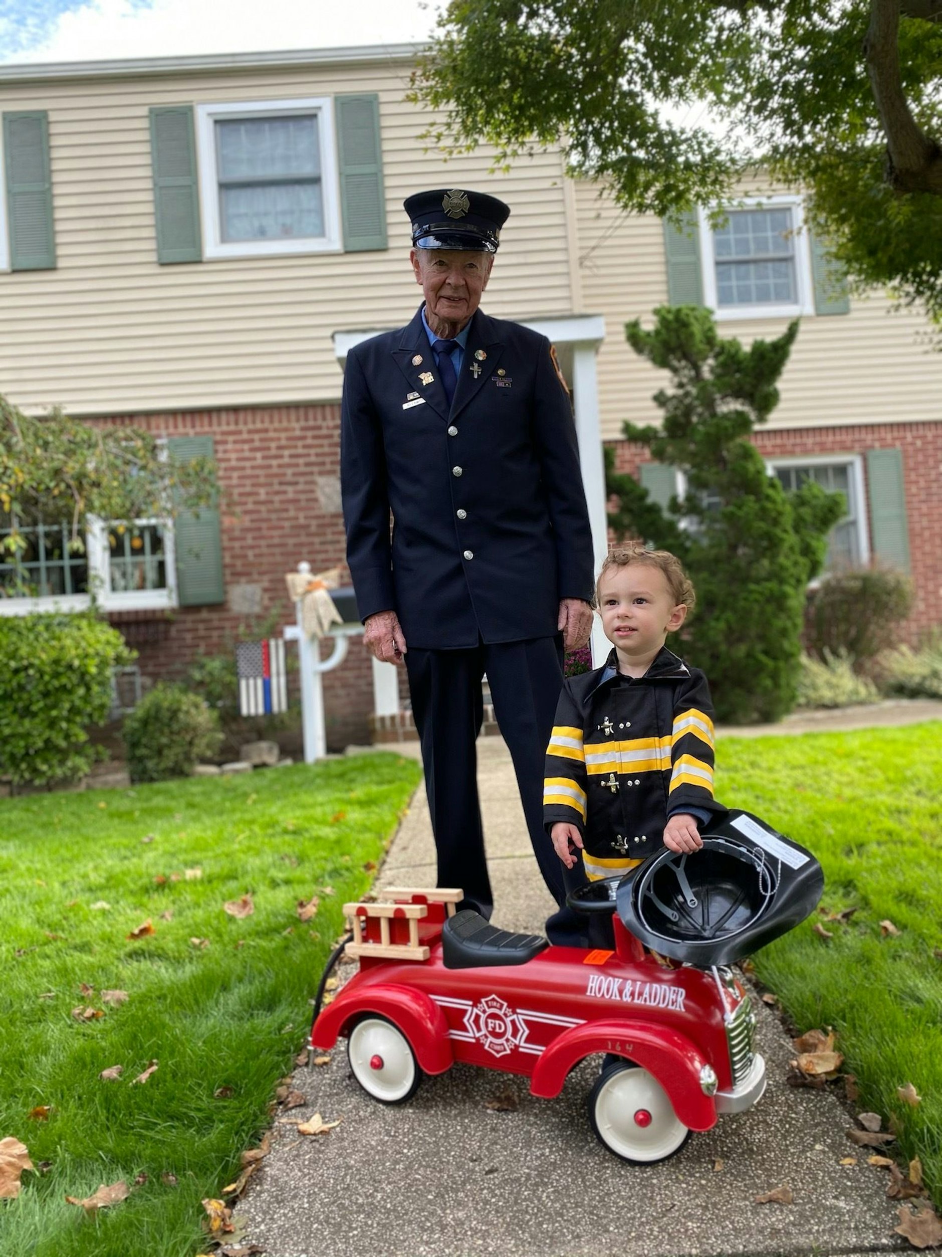 Bob Beckwith steht mit seinem Urenkel im Garten.