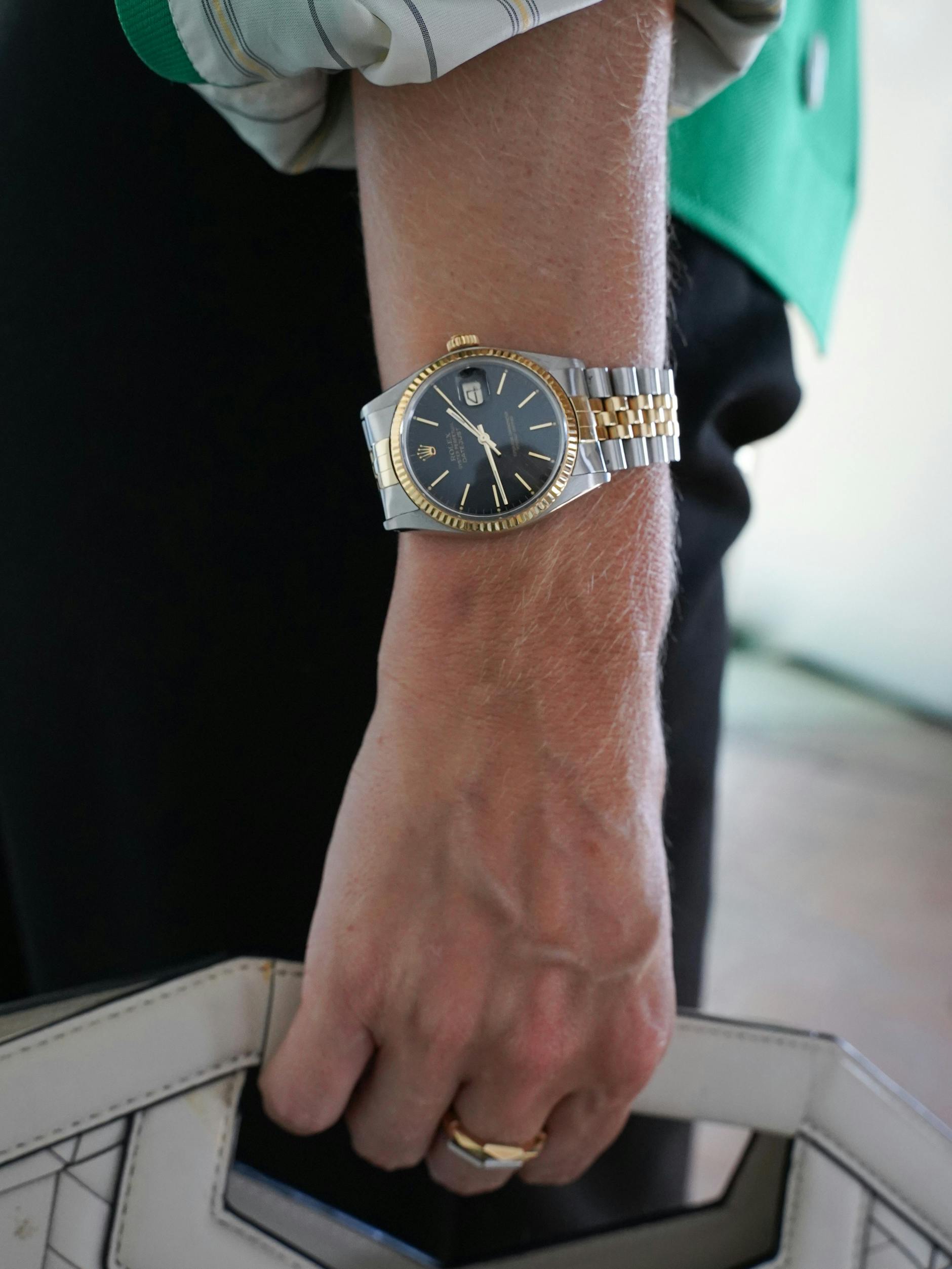 Cloudys Handgelenk ziert eine Rolex Datejust mit geriffelter Lünette, Jubilee-Armband und Gelbgold-Elementen. Die Ringe sind von Gucci.