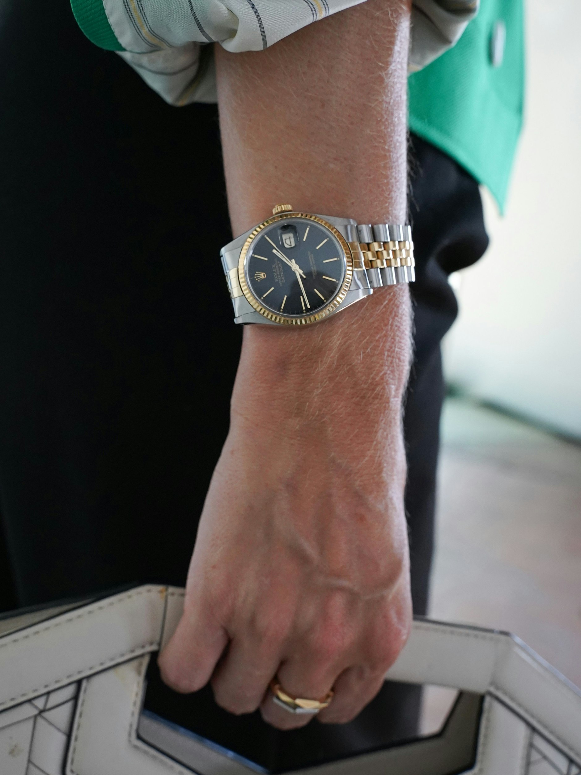 Cloudys Handgelenk ziert eine Rolex&nbsp;Datejust mit geriffelter Lünette, Jubilee-Armband und Gelbgold-Elementen. Die Ringe sind von Gucci.