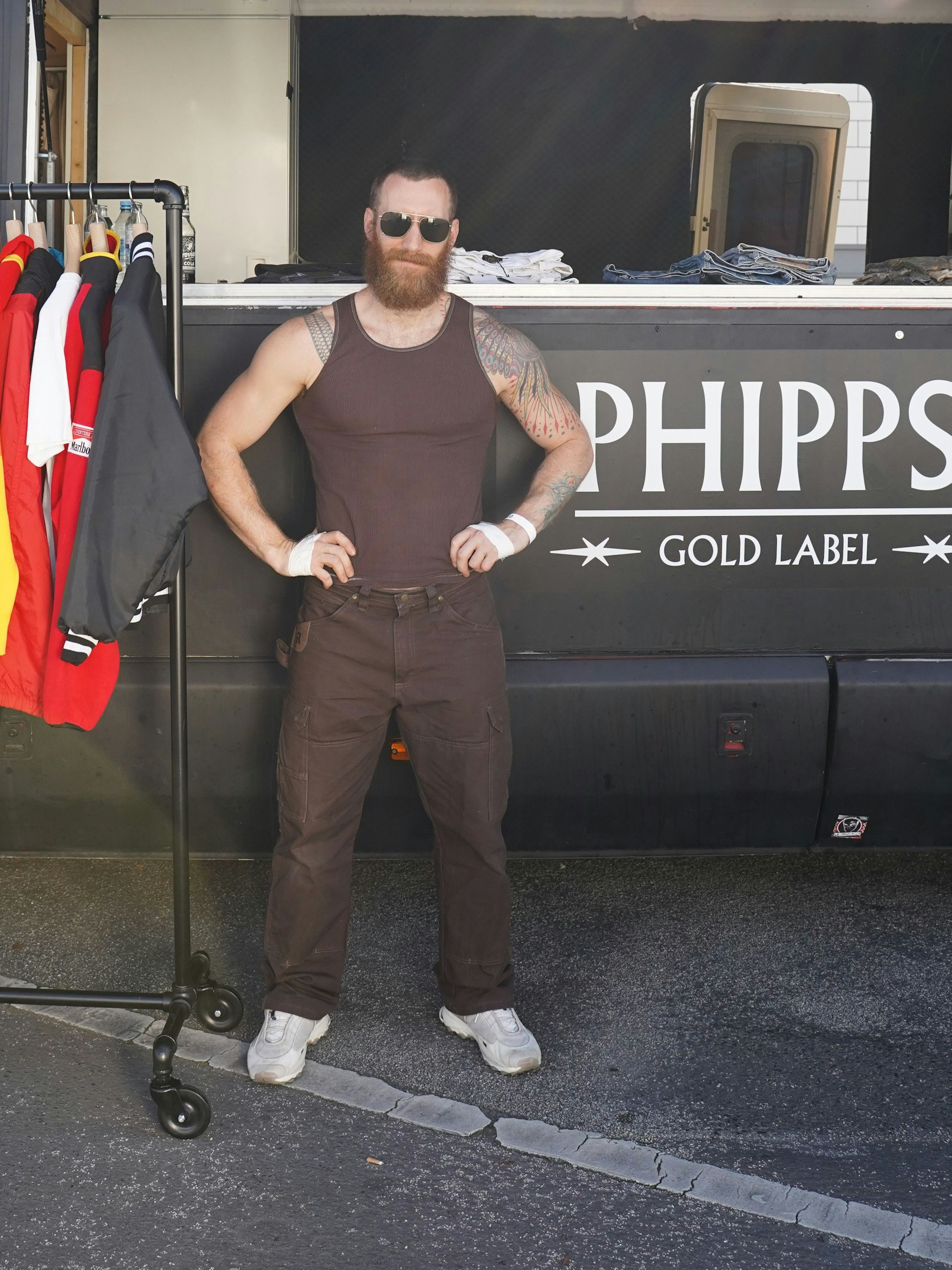 Spencer präsentiert sich und sein Pariser Label Phipps mit einem Pop-up-Store am Fuße des Bierpinsels. Der aus San Francisco stammende Modemacher hat bereits für Marc Jacobs und&nbsp;Dries Van Noten gearbeitet, seit 2019 ist Phipps im offiziellen Schauenkalender in Paris zu sehen. Auf dem Reference-Festival zeigt er seine neueste Upcycling-Kollektion. Sein Outfit („Yes, I like brown“): Shirt Phipps, Hose Wrangler Workwear, Sneakers adidas adiprene, Brille Celine.
