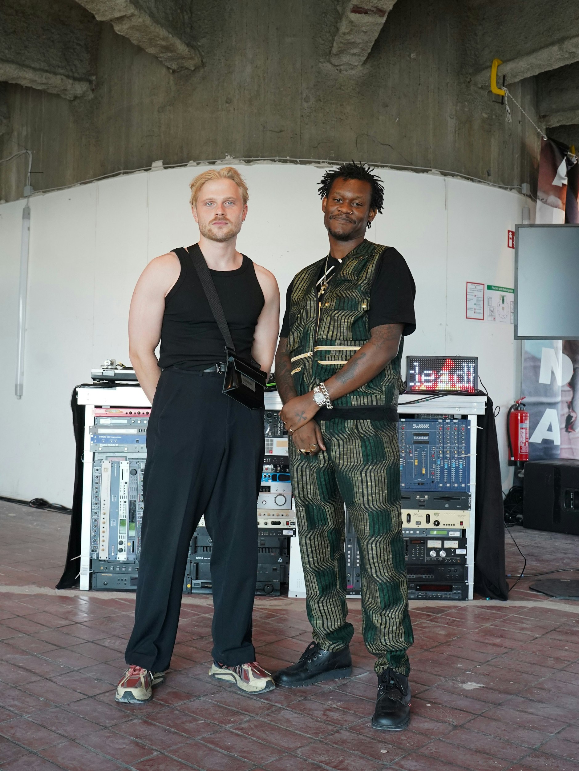 Fashion Consultant Christopher und Modesigner Bernard vor ihrer Installation im Bierpinsel. Bernard betreibt das Label Deadhype, für das beide arbeiten. Christopher trägt Beaumont Studios (Top), Asos Design (Hose) und Li-Ning (Sneakers). Bernard trägt zum T-Shirt von Craig Green einen selbst entworfenen Zweiteiler von Deadhpye und dazu Schuhe von Kickers.