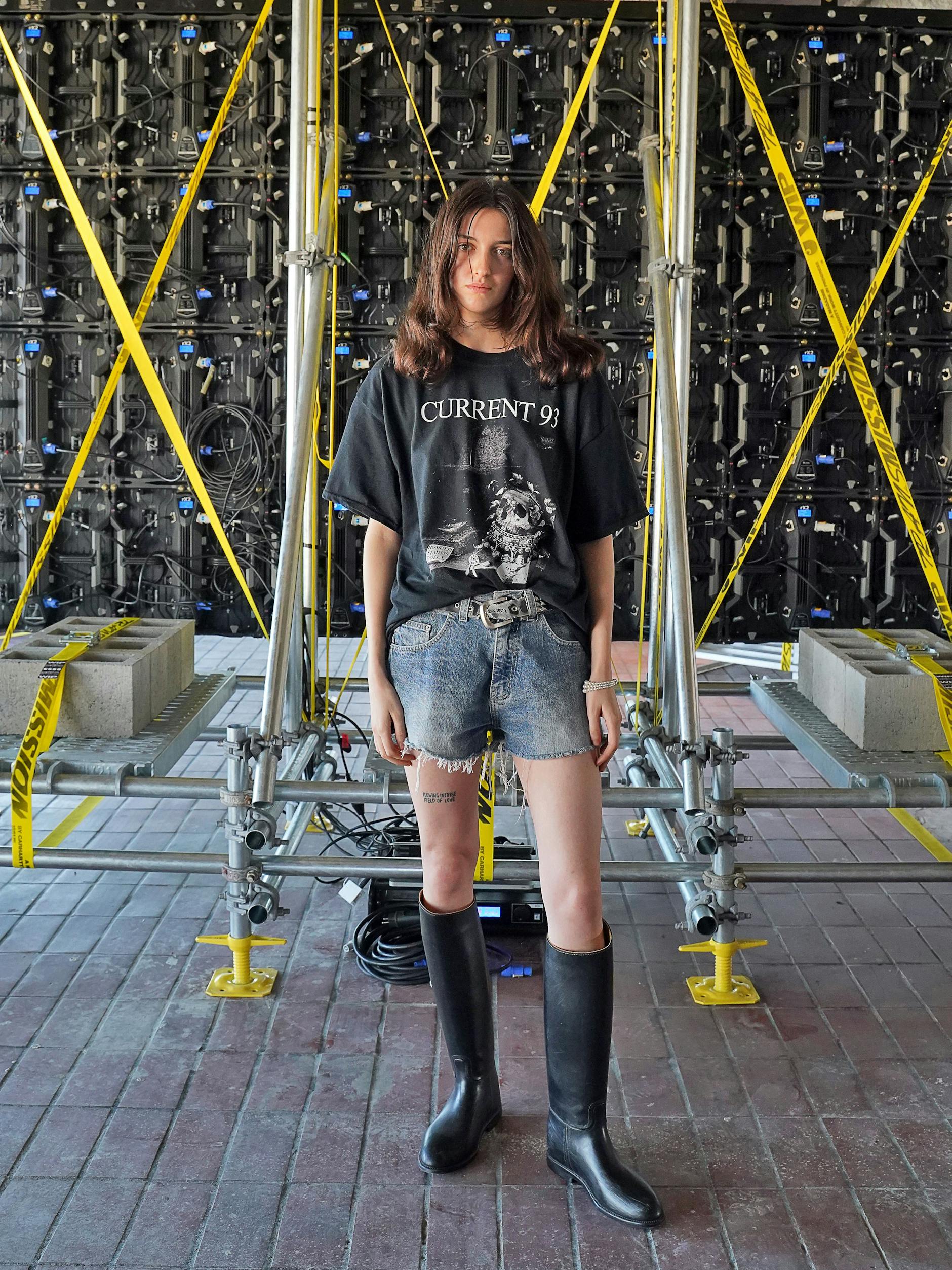 Monacco ist Model und wohnt seit einem Jahr in Berlin. Die Kanadierin besucht das Reference Festival in einem Outfit, das aus nur wenigen Teilen besteht: Band-T-Shirt, Vintage-Jeans-Shorts und Gummistiefel von Aigle, die sie in einem Secondhandshop in Charlottenburg gekauft hat (ja, es war sehr warm an den Füßen). Den Gürtel hat sie von ihrer Stiefmutter in Vancouver „gestohlen“, wie Monacco sagt.
