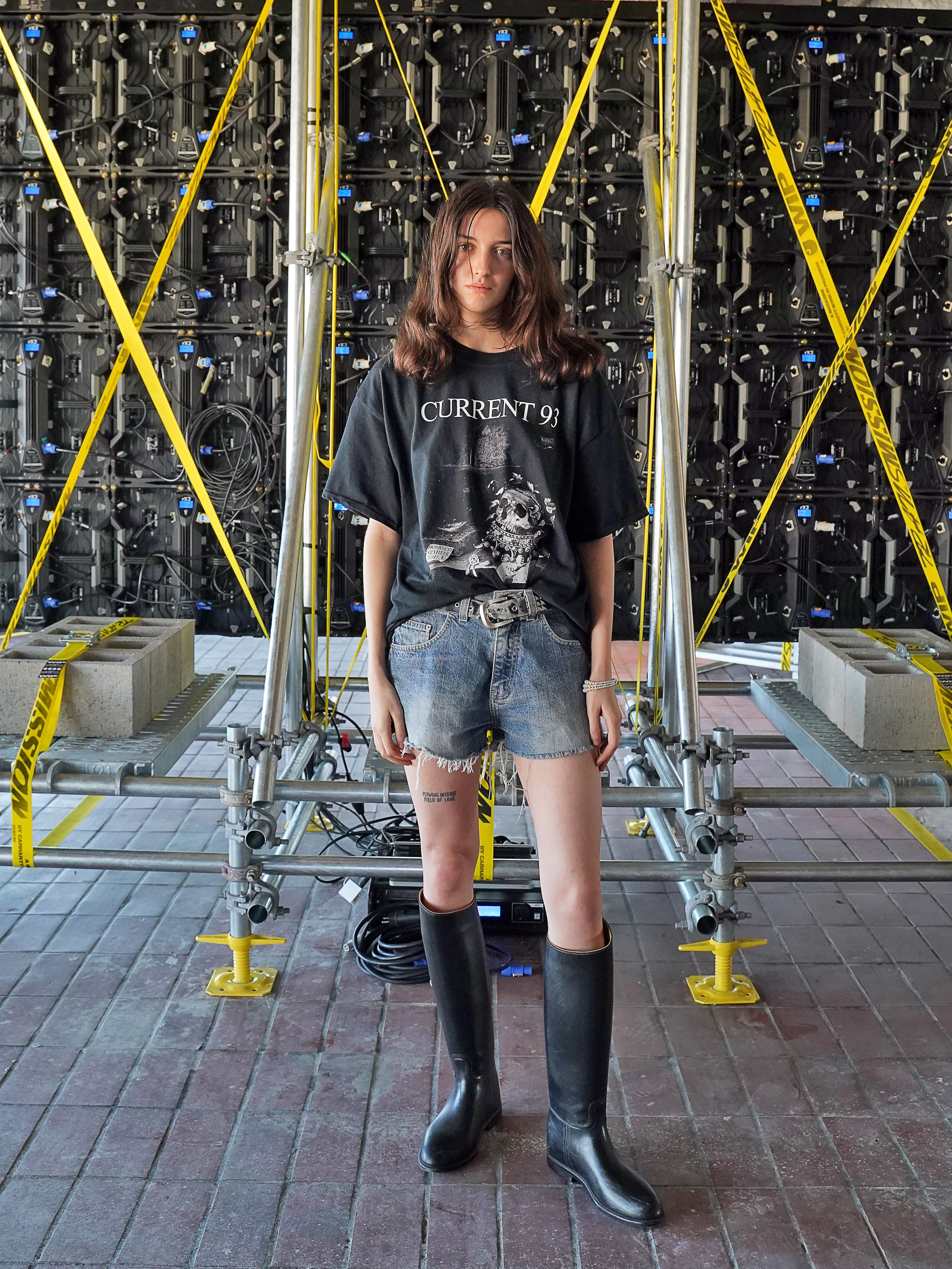 Monacco ist Model und wohnt seit einem Jahr in Berlin. Die Kanadierin&nbsp; besucht das Reference Festival in einem Outfit, das aus nur wenigen Teilen besteht: Band-T-Shirt, Vintage-Jeans-Shorts und Gummistiefel von Aigle, die sie in einem Secondhandshop in Charlottenburg gekauft hat (ja, es war sehr warm an den Füßen). Den Gürtel hat sie von ihrer Stiefmutter in Vancouver „gestohlen“, wie Monacco sagt.