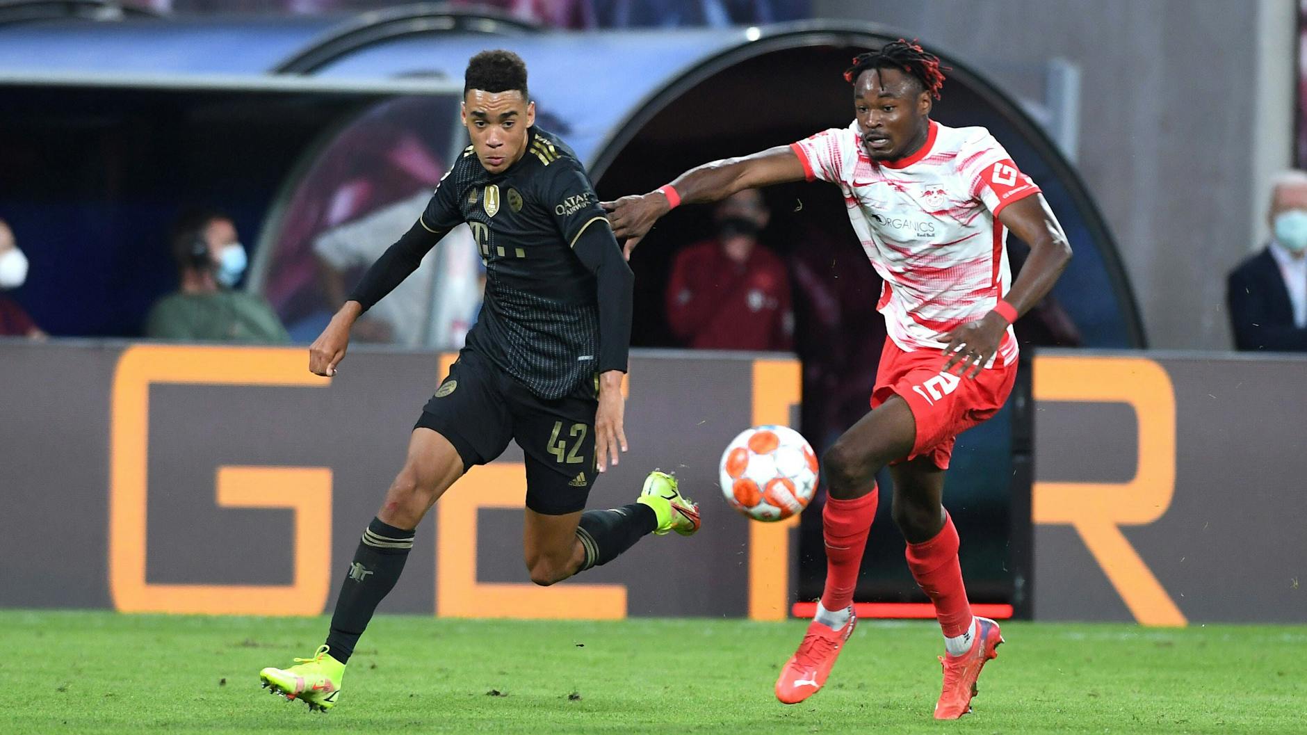 Bayerns Jamal Musiala und Leipzigs Mohamed Simakan Leipzig im Kampf um den Ball.